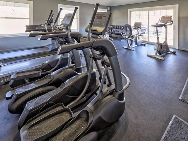 Elliptical machines and treadmills in a gym fitness area at Willowtree Apartments & Tower in Ann Arbor Student Accommodation