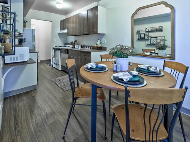 Table with placemats and kitchen with appliances dining area at Willowtree Apartments & Tower in Ann Arbor Student Accommodation