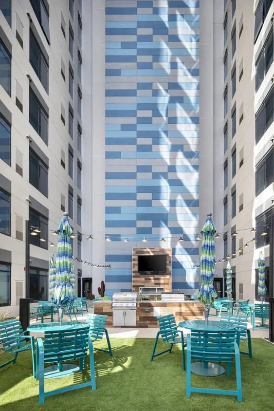 Outdoor kitchen grill umbrellas and tables courtyard exterior at Atmosphere Tempe in Tempe Student Accommodation