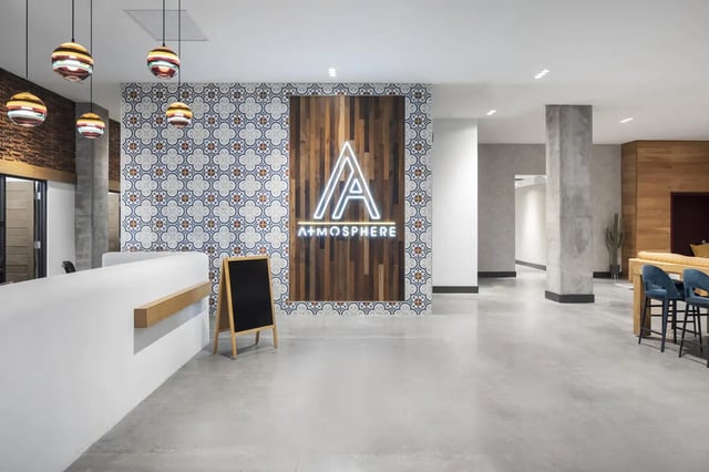 Reception desk logo tile wall chalkboard and chairs lobby at Atmosphere Tempe in Tempe Student Accommodation