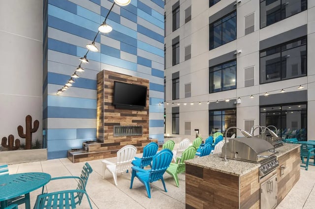 Outdoor patio with grill, seating, TV, fireplace, and chairs. at Atmosphere Tempe in Tempe Student Accommodation