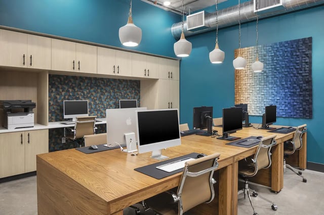 Computers and chairs at a long table study area at Atmosphere Tempe in Tempe Student Accommodation