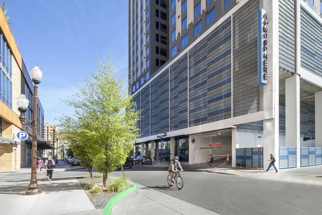 Modern building exterior with people cycling and walking exterior at Atmosphere Tempe in Tempe Student Accommodation