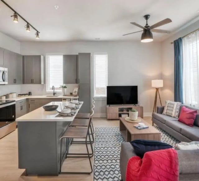 Kitchen island sofa television living room interior at The Yards at Old State in State College Student Accommodation