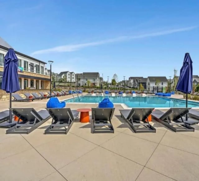 Poolside lounge chairs blue beanbags and small table exterior at The Yards at Old State in State College Student Accommodation