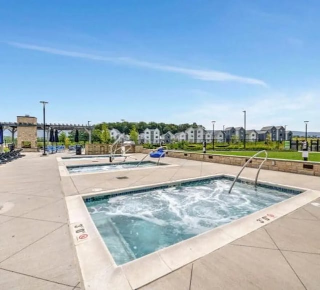 Hot tubs on patio near apartment buildings exterior at The Yards at Old State in State College Student Accommodation
