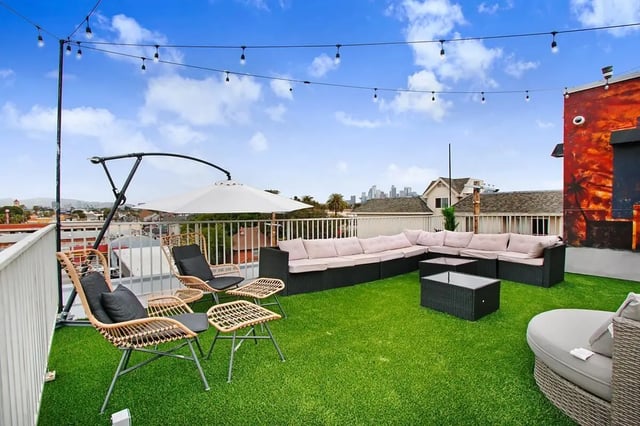 Outdoor lounge seating with turf and string lights exterior at USC Student Housing: Heritage 1275 in Los Angeles Student Accommodation