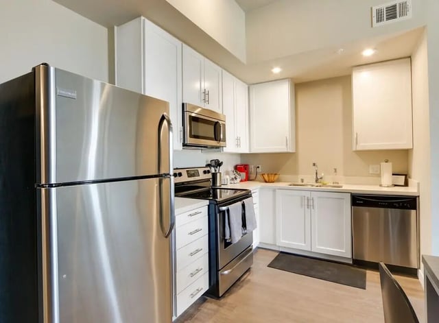 Stainless steel appliances and white cabinets kitchen at USC Student Housing: Heritage 1275 in Los Angeles Student Accommodation