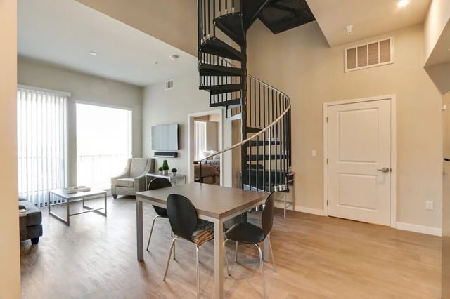 Spiral staircase with dining table living area living room at USC Student Housing: Heritage 1275 in Los Angeles Student Accommodation