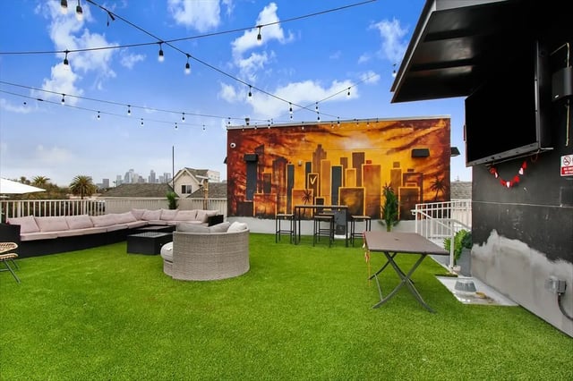 Rooftop lounge area with seating and city mural exterior at USC Student Housing: Heritage 1275 in Los Angeles Student Accommodation