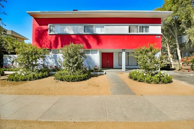 Red stucco building with modern windows exterior at USC Student Housing: Victory Trio California Suites in Los Angeles Student Accommodation