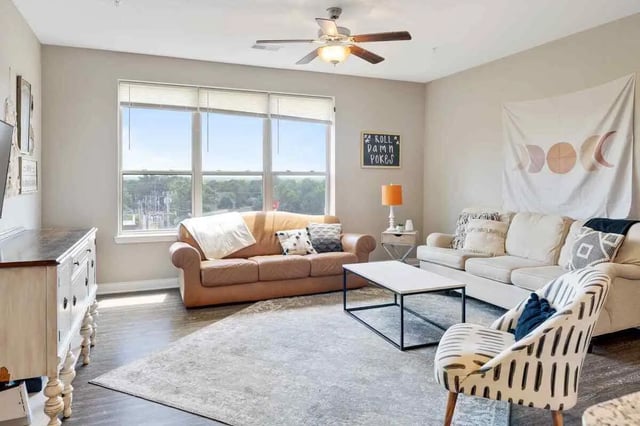 Two sofas rug coffee table and armchair living room at Midtown Stillwater Student Apartments in Stillwater Student Accommodation