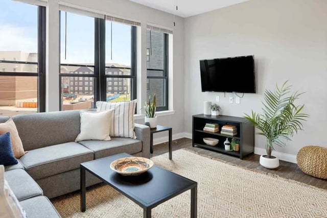 Grey sectional sofa black coffee table living room at Midtown Stillwater Student Apartments in Stillwater Student Accommodation