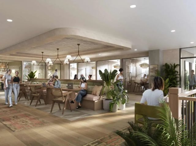 People studying at tables with plants and seating area. at Rambler Tempe Apartments in Tempe Student Accommodation