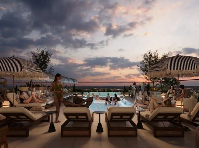 People relaxing by pool lounge chairs and umbrellas playing area at Rambler Tempe Apartments in Tempe Student Accommodation