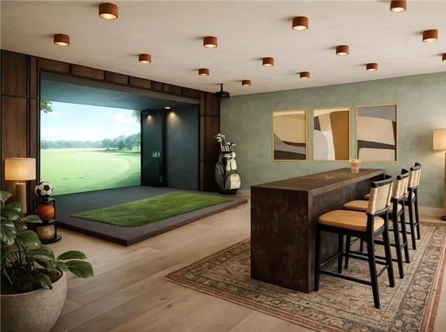 Golf simulator and bar area with golf bag and chairs. at Rambler Tempe Apartments in Tempe Student Accommodation