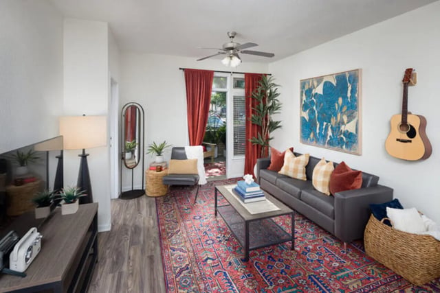 Sofa coffee table rug and guitar living room at Stadium Enclave in Tallahassee Student Accommodation