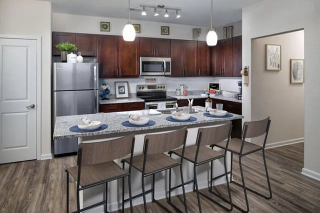Kitchen island with stools and stainless steel appliances kitchen at Stadium Enclave in Tallahassee Student Accommodation