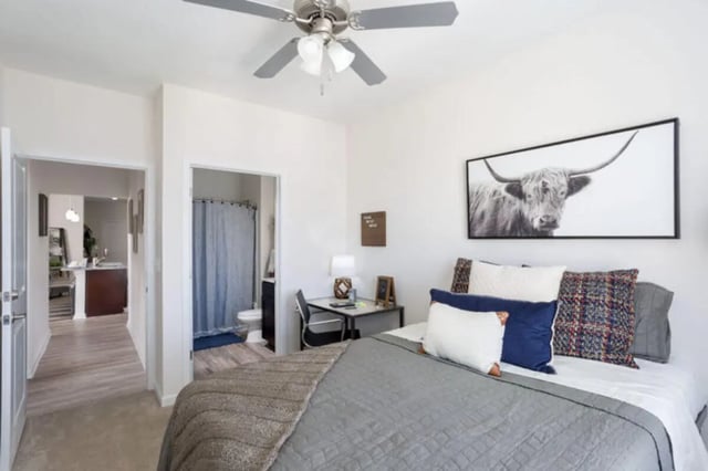 Bed with pillows desk and bull art bedroom at Stadium Enclave in Tallahassee Student Accommodation
