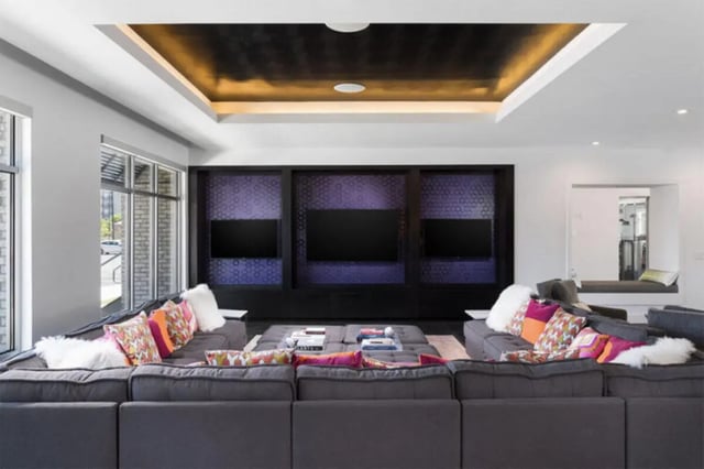 Modular sofa with patterned pillows and three TVs living room at Stadium Enclave in Tallahassee Student Accommodation