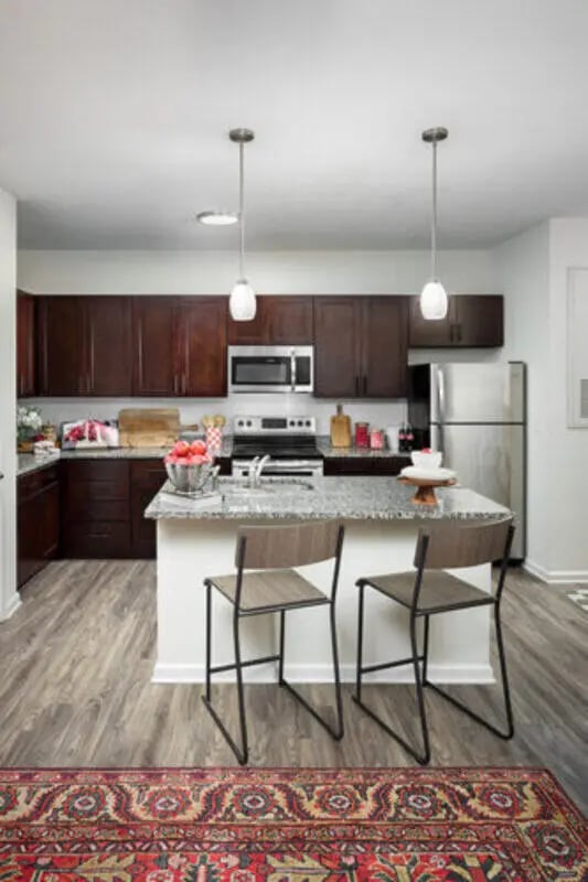 Dark cabinets island with stools kitchen at Stadium Enclave in Tallahassee Student Accommodation