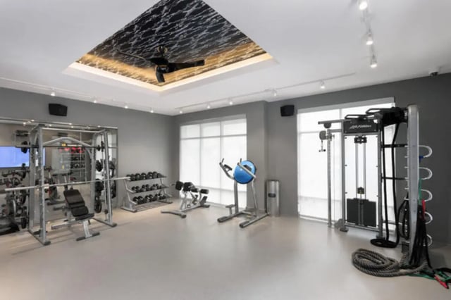 Weight racks exercise machines and bench gym room at Stadium Enclave in Tallahassee Student Accommodation