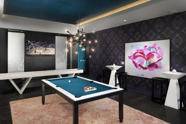 Pool table shuffleboard television large painting recreation room at Stadium Enclave in Tallahassee Student Accommodation