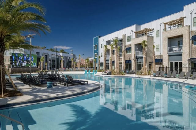 Pool lounge chairs apartment building exterior at Stadium Enclave in Tallahassee Student Accommodation