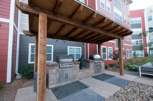 Outdoor kitchen with grills and seating area at Park East Student Living in Lubbock Student Accommodation