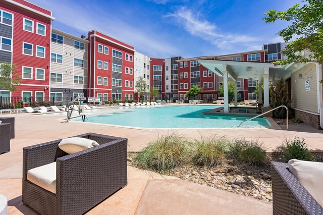Wicker chairs with cushions pool and cabana exterior at Park East Student Living in Lubbock Student Accommodation