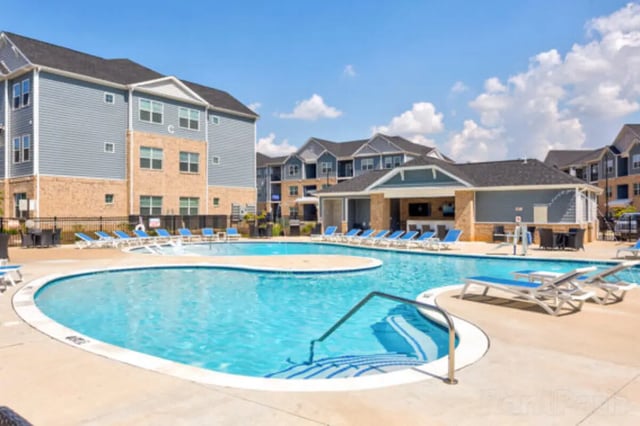 Resort-style pool with lounge chairs and buildings exterior at Stadium View in Jonesboro Student Accommodation