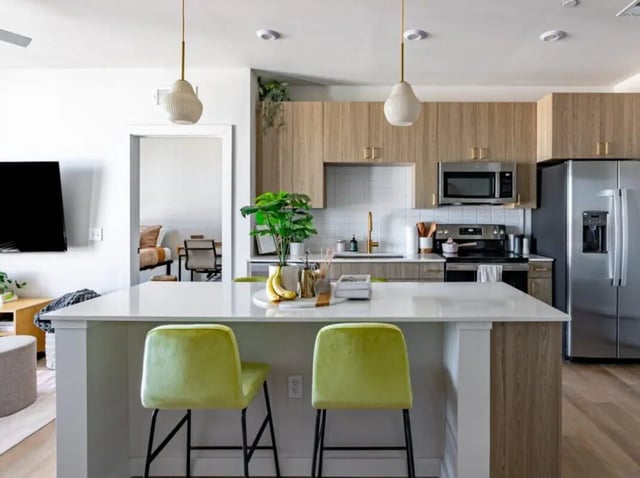 Kitchen island with green stools kitchen appliances and cabinets kitchen at Sweetwater Gainesville Apartments in Gainesville Student Accommodation