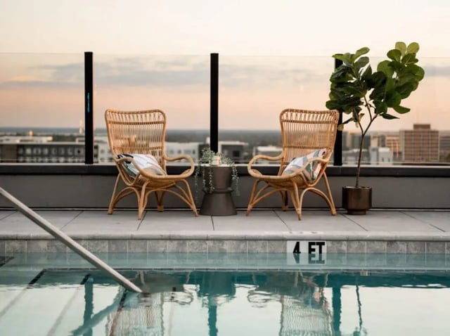 Two wicker chairs and plant by pool exterior at Sweetwater Gainesville Apartments in Gainesville Student Accommodation