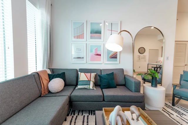 Grey sectional sofa artwork above arched mirror living room at Lapis in Miami Student Accommodation