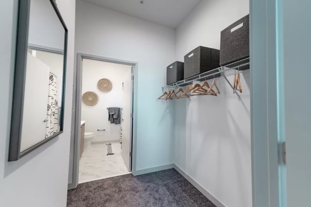 Closet with shelves boxes hangers and open bathroom area at Lapis in Miami Student Accommodation