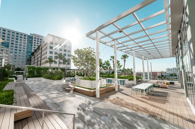 Outdoor seating area with tables chairs and lounge cushions exterior at Lapis in Miami Student Accommodation