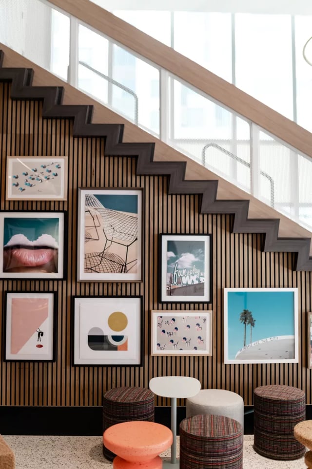 Wall art and ottomans beneath a staircase Living Area at Lapis in Miami Student Accommodation