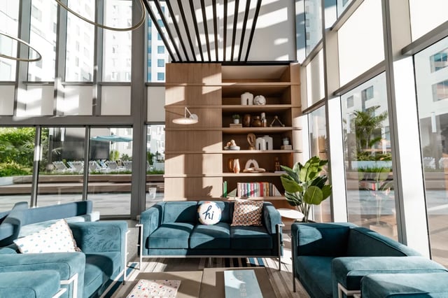 Blue sofas by bookshelf and large windows Living room at Lapis in Miami Student Accommodation