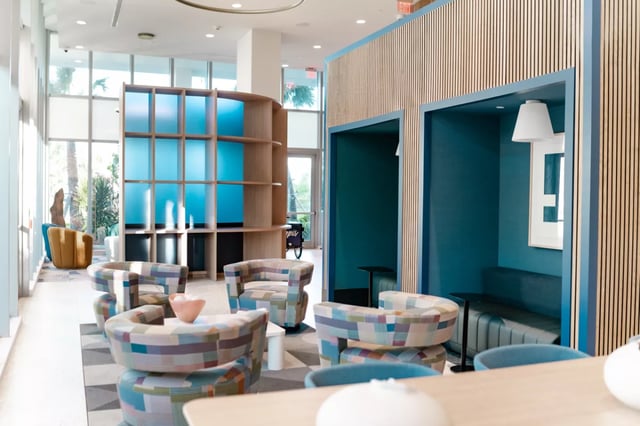 Colorful lounge chairs shelving booths and artwork Living area at Lapis in Miami Student Accommodation