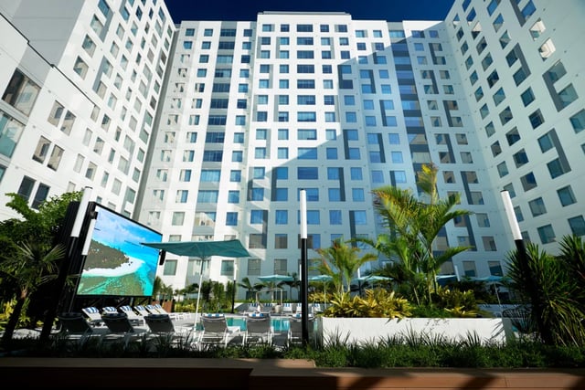 Tall building pool lounge chairs outdoor screen exterior at Lapis in Miami Student Accommodation