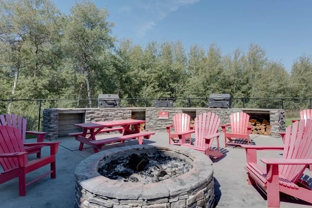 Fire pit grills picnic table chairs outdoor area at The Grove Apartments Cheney in Cheney Student Accommodation