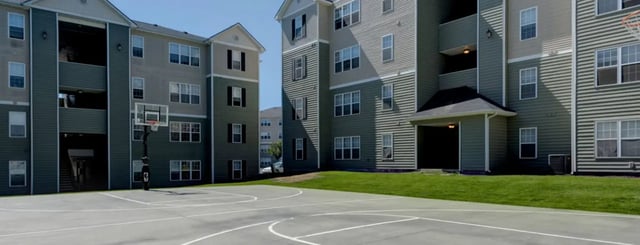 Basketball court with apartment buildings exterior at The Grove Apartments Cheney in Cheney Student Accommodation