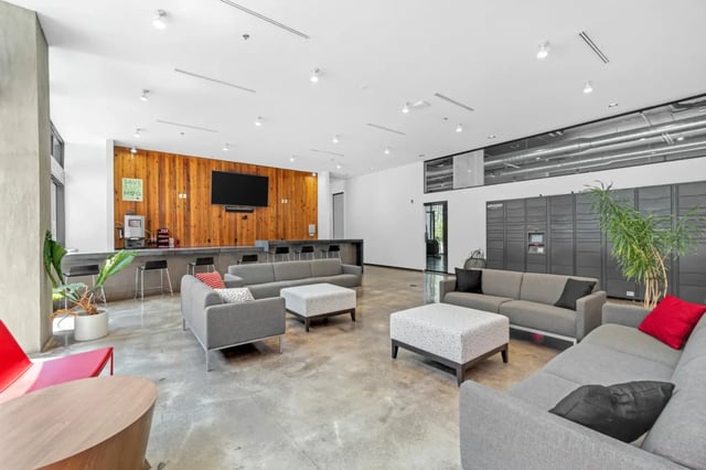 Sofa ottoman coffee bar Amazon lockers communal area at The Cardinal at West Center in Fayetteville Student Accommodation