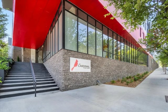 Stone building with red overhang and stairs exterior at The Cardinal at West Center in Fayetteville Student Accommodation