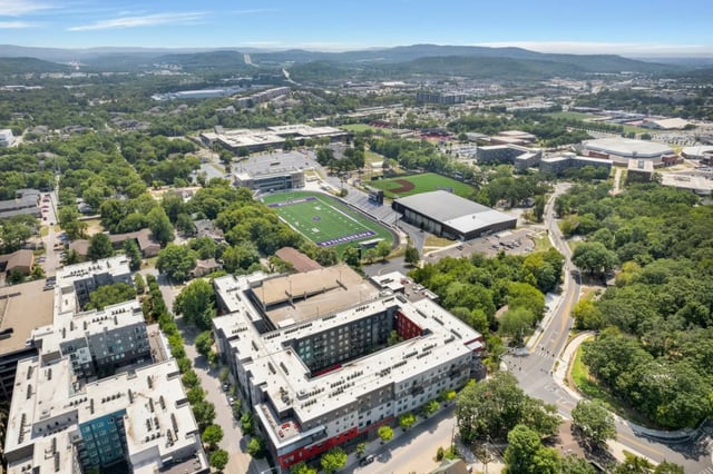 Apartment buildings near sports fields exterior at The Cardinal at West Center in Fayetteville Student Accommodation