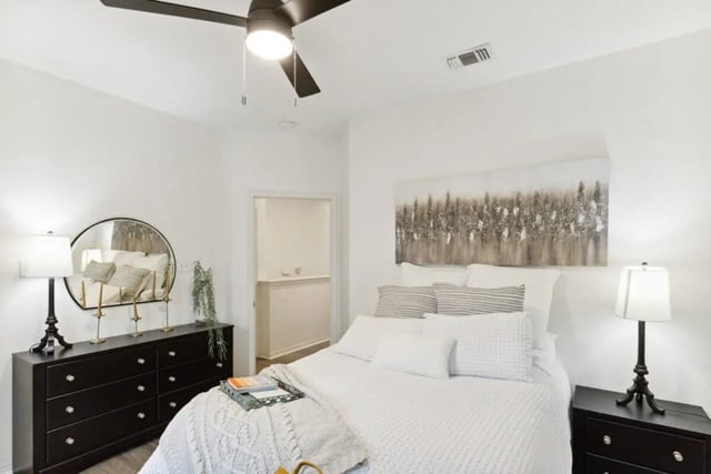 Bed dresser mirror ceiling fan artwork bedroom at The Village on Telluride in San Marcos Student Accommodation