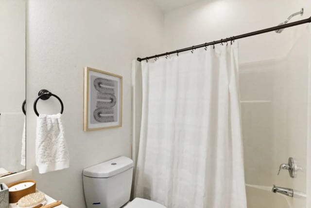 Toilet framed art towel rack shower curtain bathroom at The Village on Telluride in San Marcos Student Accommodation