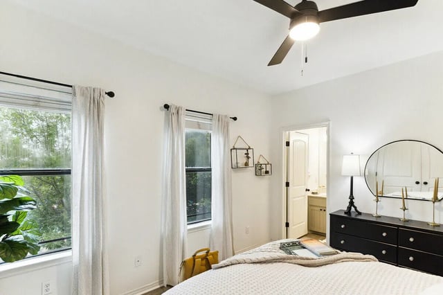 Bed with dresser lamp mirror ceiling fan bedroom at The Village on Telluride in San Marcos Student Accommodation