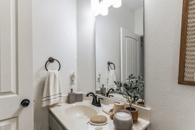 Sink towel rack soap dispenser and candle bathroom. at The Village on Telluride in San Marcos Student Accommodation