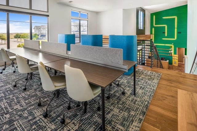 Long desk with chairs and blue cubicles study area at Wildwood Lubbock in Lubbock Student Accommodation